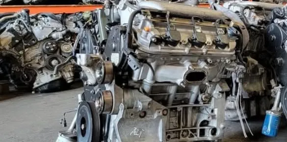 Rows of tested used engines on warehouse racks, covered by a 90-day warranty