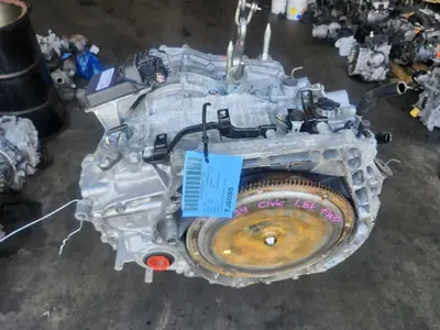 Used Honda Civic CVT automatic transmission with flywheel, hanging on a hoist