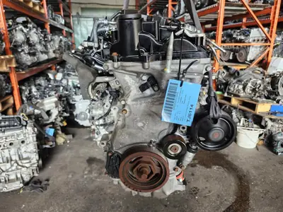 Used Honda CR-V 1.5L turbo engine with inspection tag in a parts warehouse