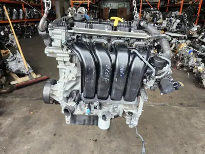 Used Kia Forte 1.8L G4NB gasoline engine on a warehouse floor